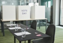 Person casting ballot in private voting booth during election