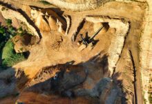 Heavy mining equipment operating in an open-pit mining site with rocky terrain