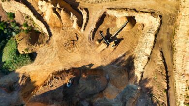 Heavy mining equipment operating in an open-pit mining site with rocky terrain