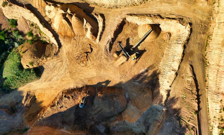 Heavy mining equipment operating in an open-pit mining site with rocky terrain