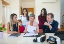 Professional family meeting around conference table discussing important documents and planning
