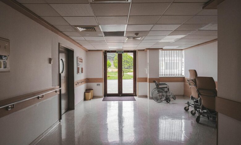 Empty hospital hallway with medical equipment and bright lighting