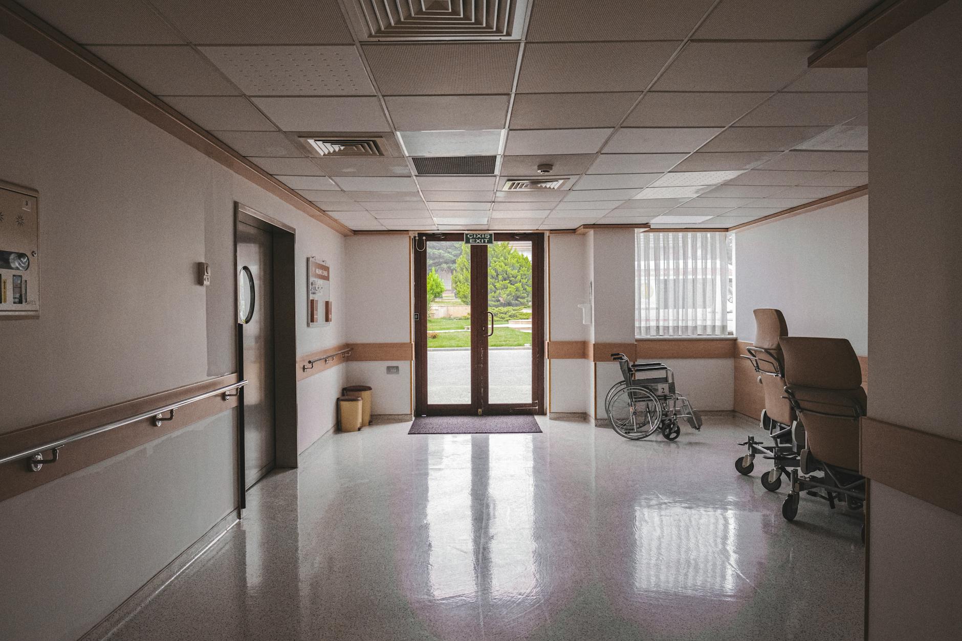 Empty hospital hallway with medical equipment and bright lighting