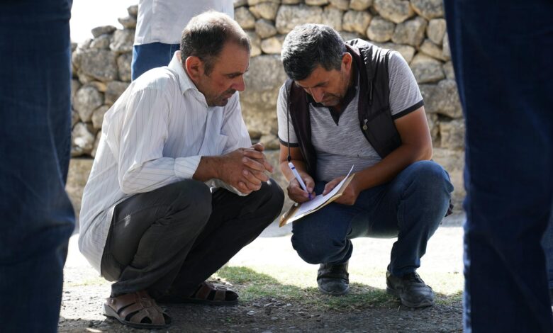 People gathered around a table in a community meeting discussing local development projects