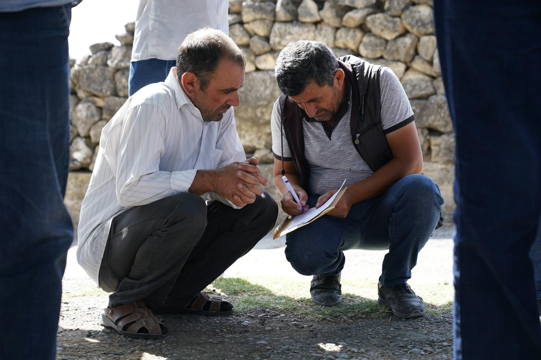 People gathered around a table in a community meeting discussing local development projects
