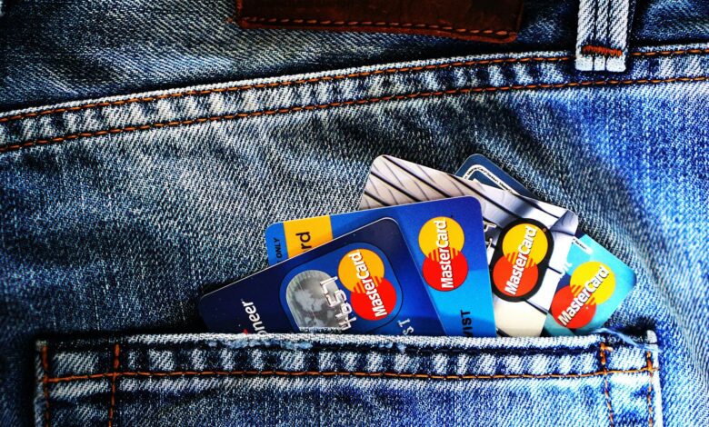 Credit cards arranged with digital wallet showing cryptocurrency transactions