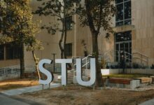 Students walking across university campus quad with academic buildings in background