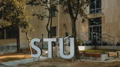 Students walking across university campus quad with academic buildings in background