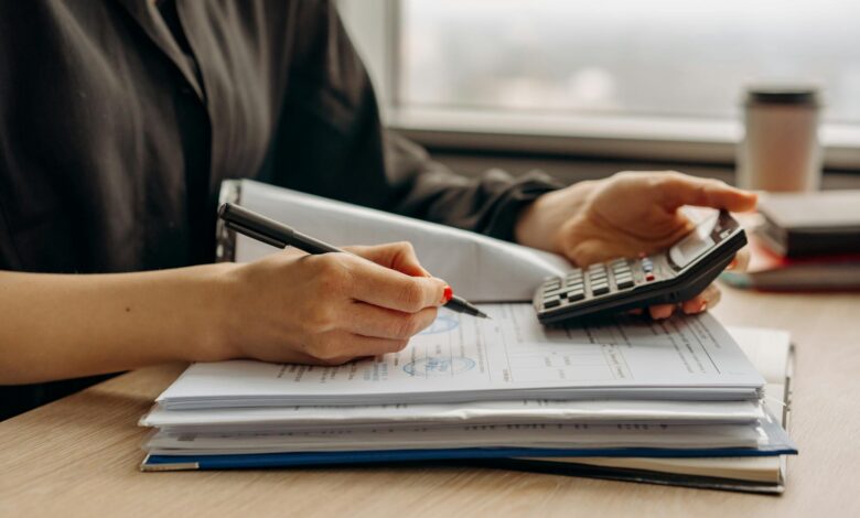 Calculator and financial documents on desk representing loan payment calculations