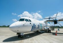 Passengers boarding commercial airplane at airport gate