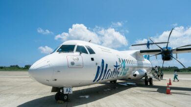 Passengers boarding commercial airplane at airport gate