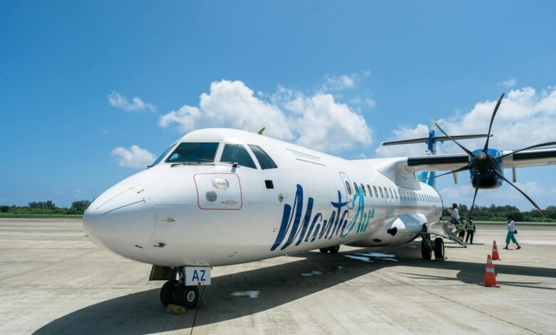 Passengers boarding commercial airplane at airport gate