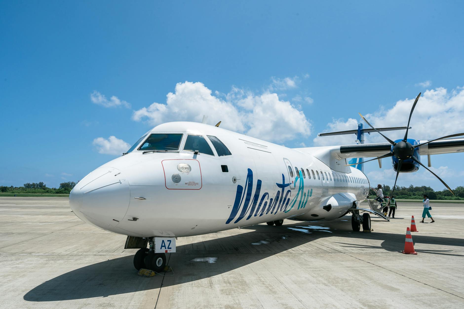 Passengers boarding commercial airplane at airport gate