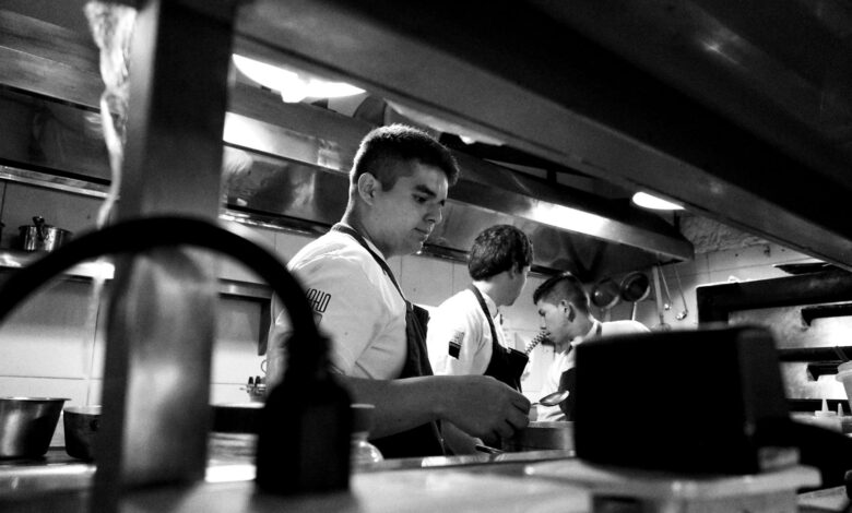 Busy restaurant kitchen with multiple chefs working during peak hours