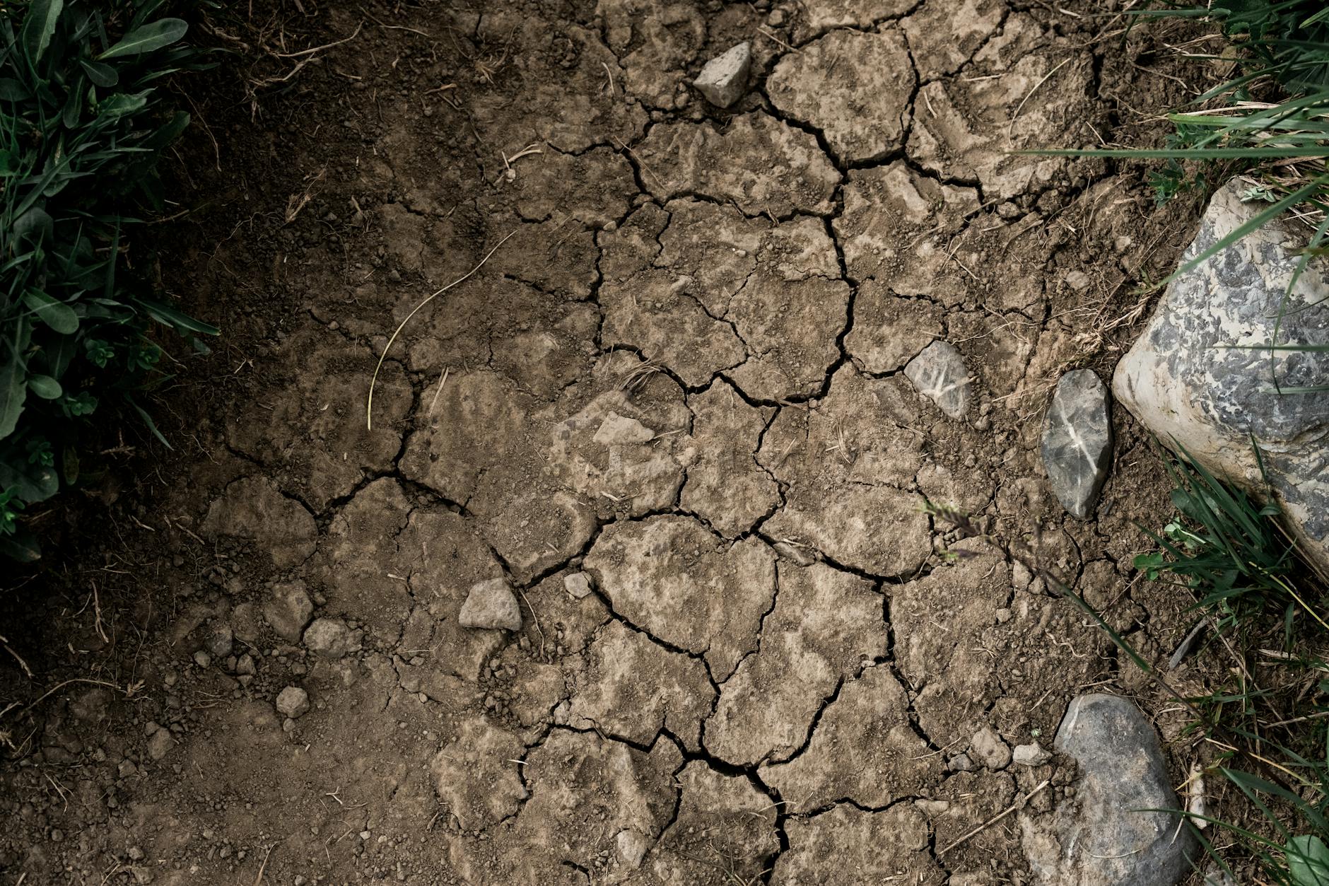 Aerial view of drought-affected landscape with dried riverbed and sparse vegetation in Western United States