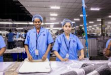 Manufacturing workers operating modern industrial equipment in a clean factory environment