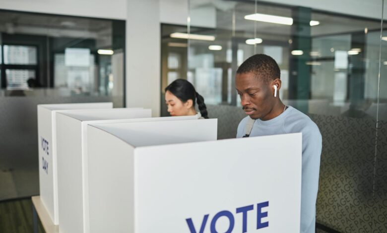 Person marking ballot in voting booth with privacy screen