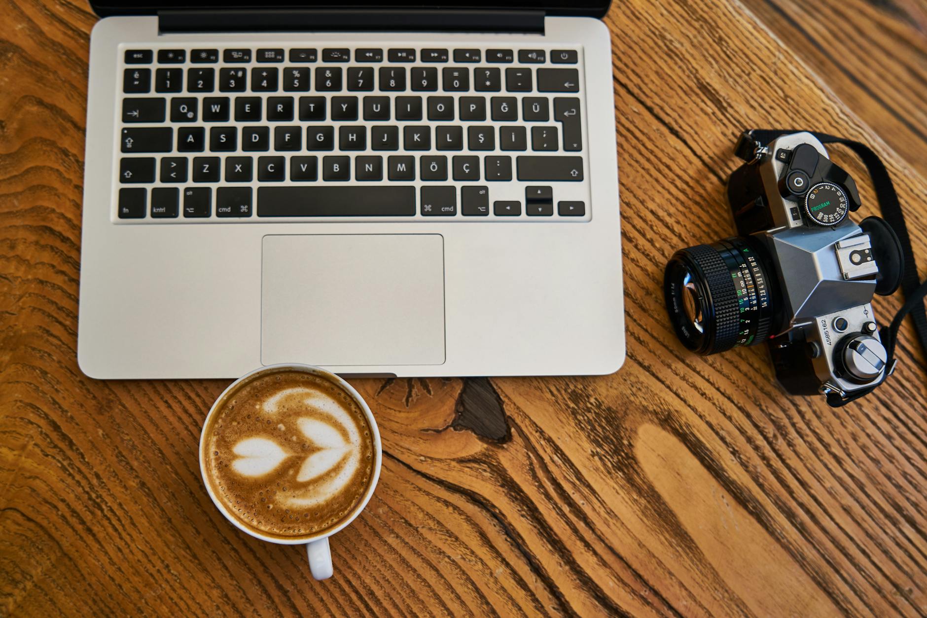 Person working on laptop with coffee cup, representing remote side hustle work