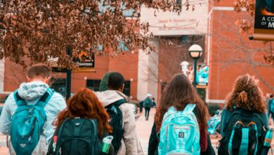 Students walking across university campus quad with academic buildings in background