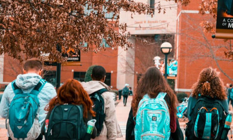 Students walking across university campus quad with academic buildings in background