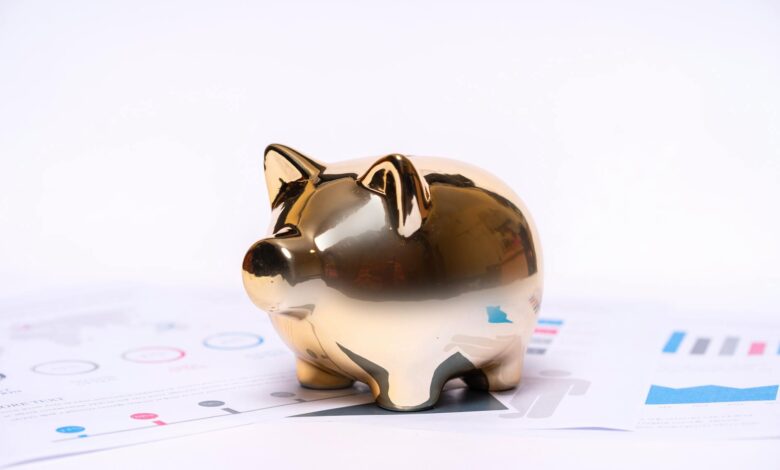 Financial advisor reviewing investment documents and charts at desk with calculator and laptop