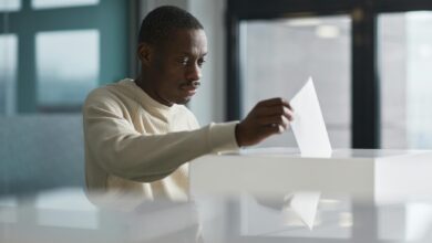 Ballot box with voting papers being inserted during election process