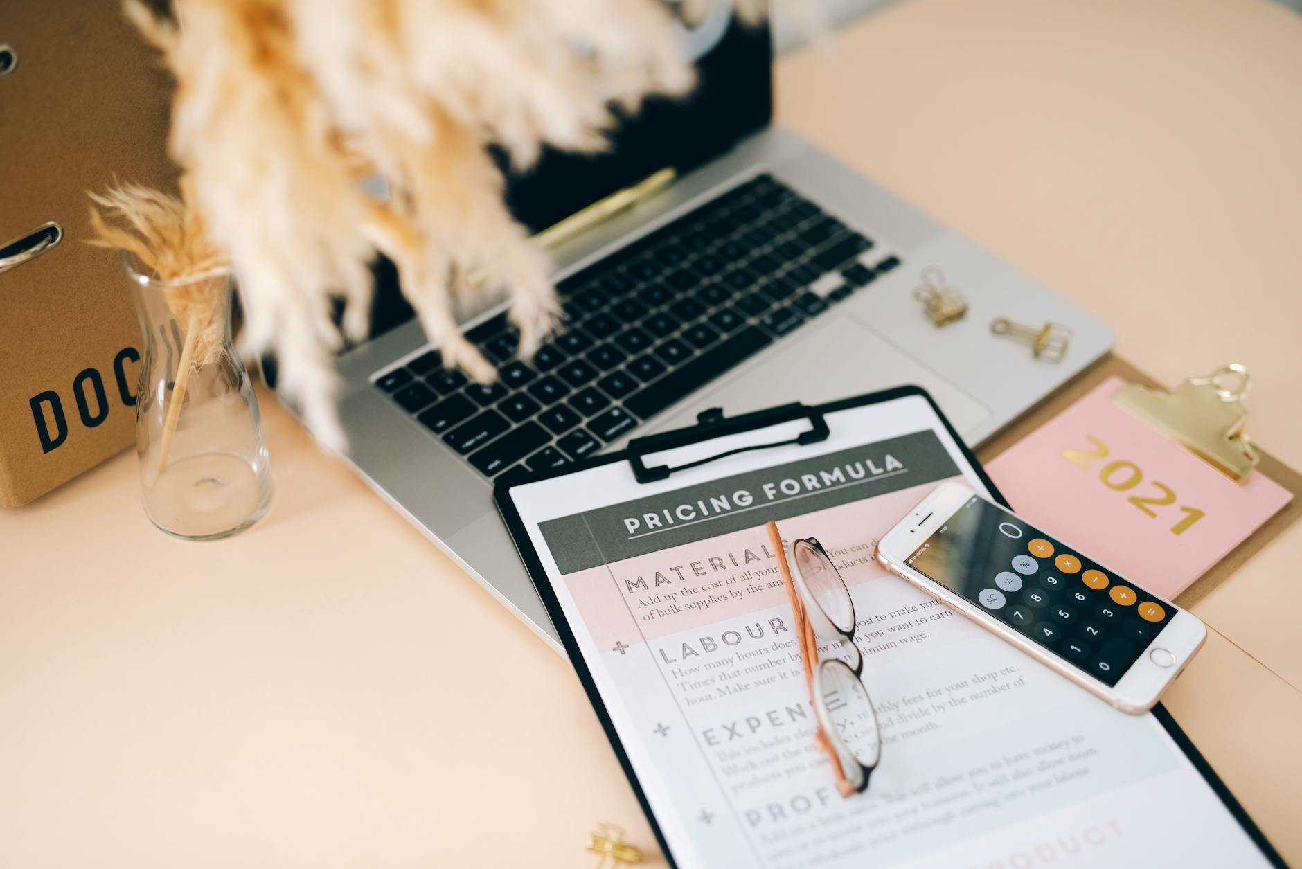 Laptop computer with calculator and financial documents on desk for loan processing