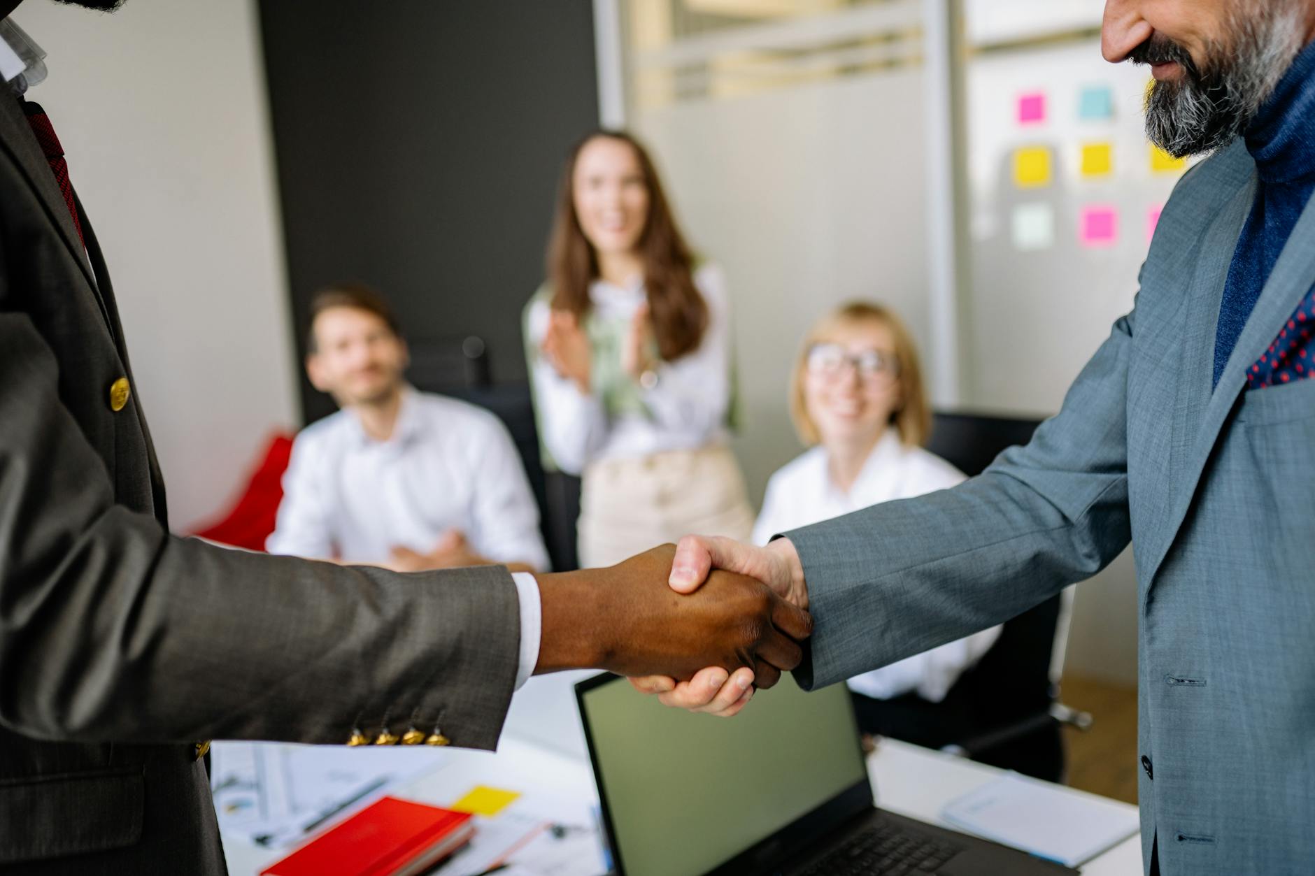 Business professionals shaking hands during partnership meeting