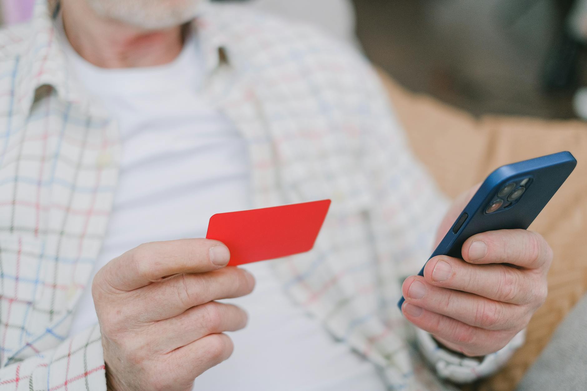 Person using smartphone to access mobile banking application on screen