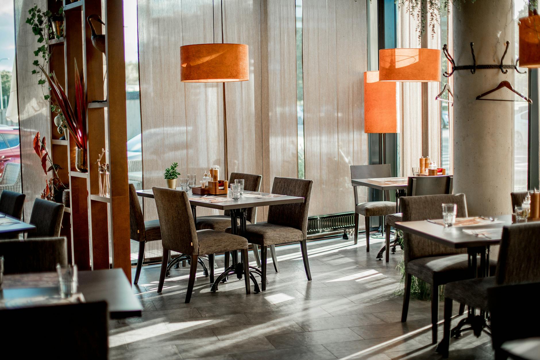 Empty restaurant dining room with tables set for lunch service