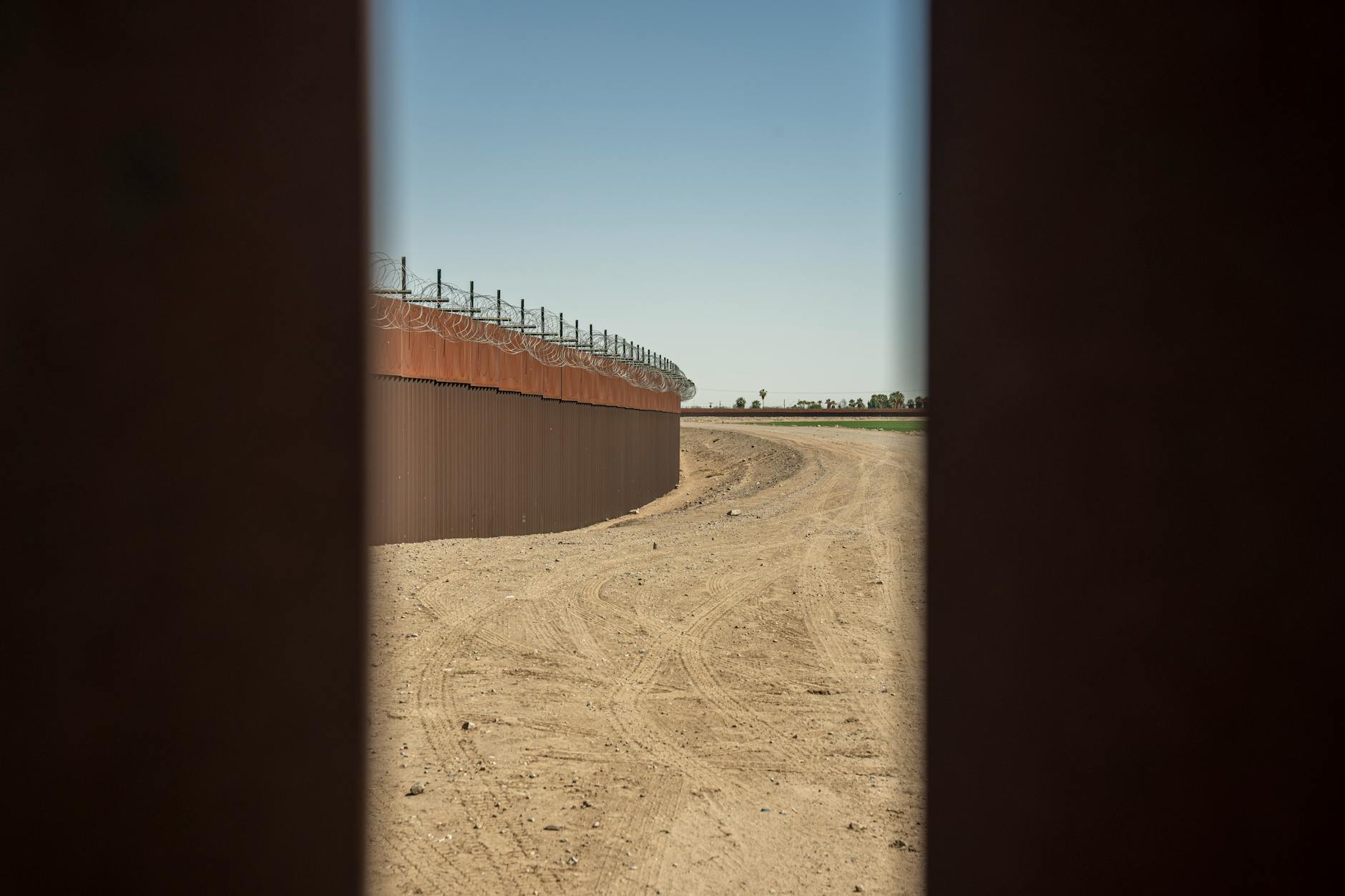 Security border fence with barbed wire along international boundary