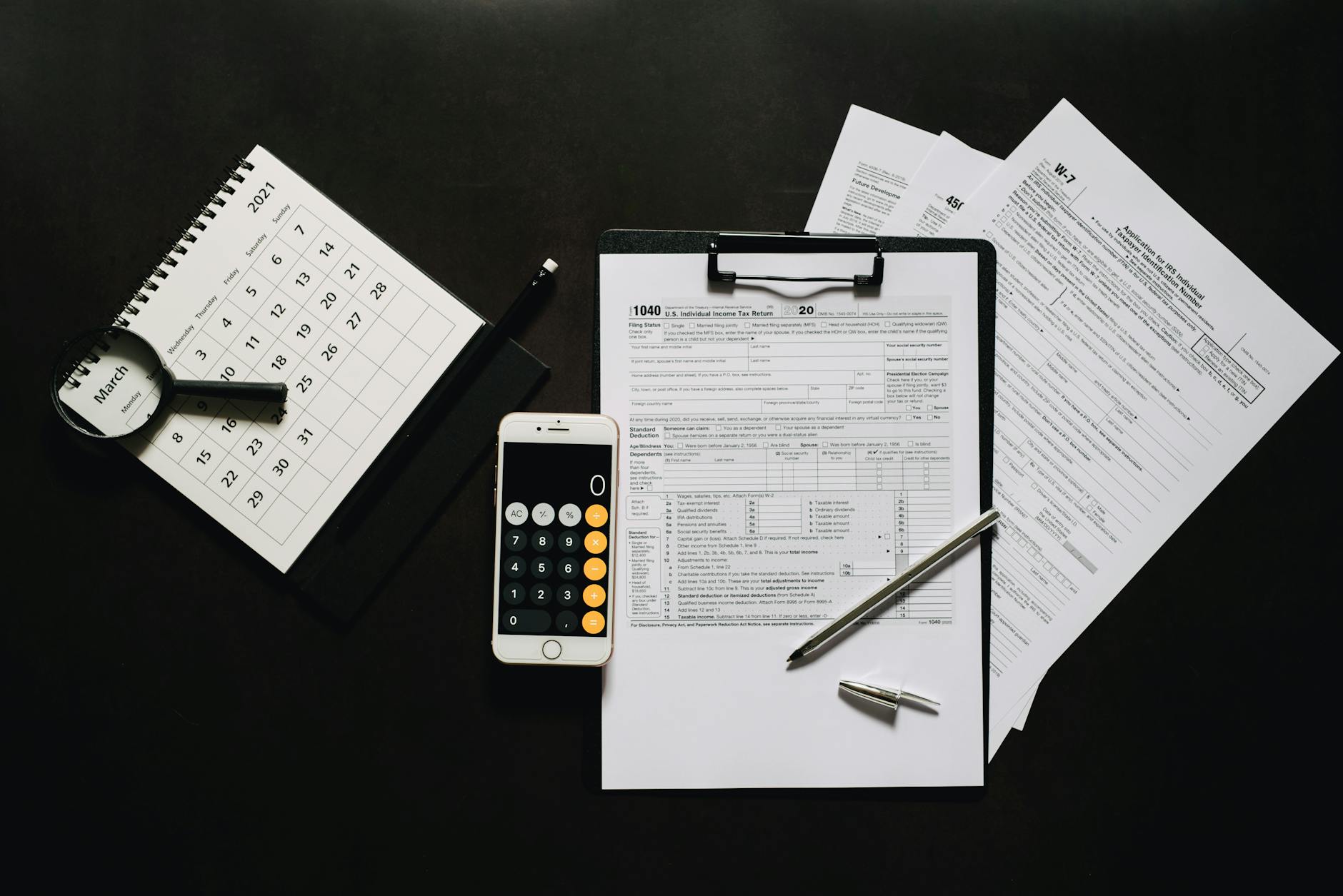 Financial calculator and tax documents spread across desk during planning session