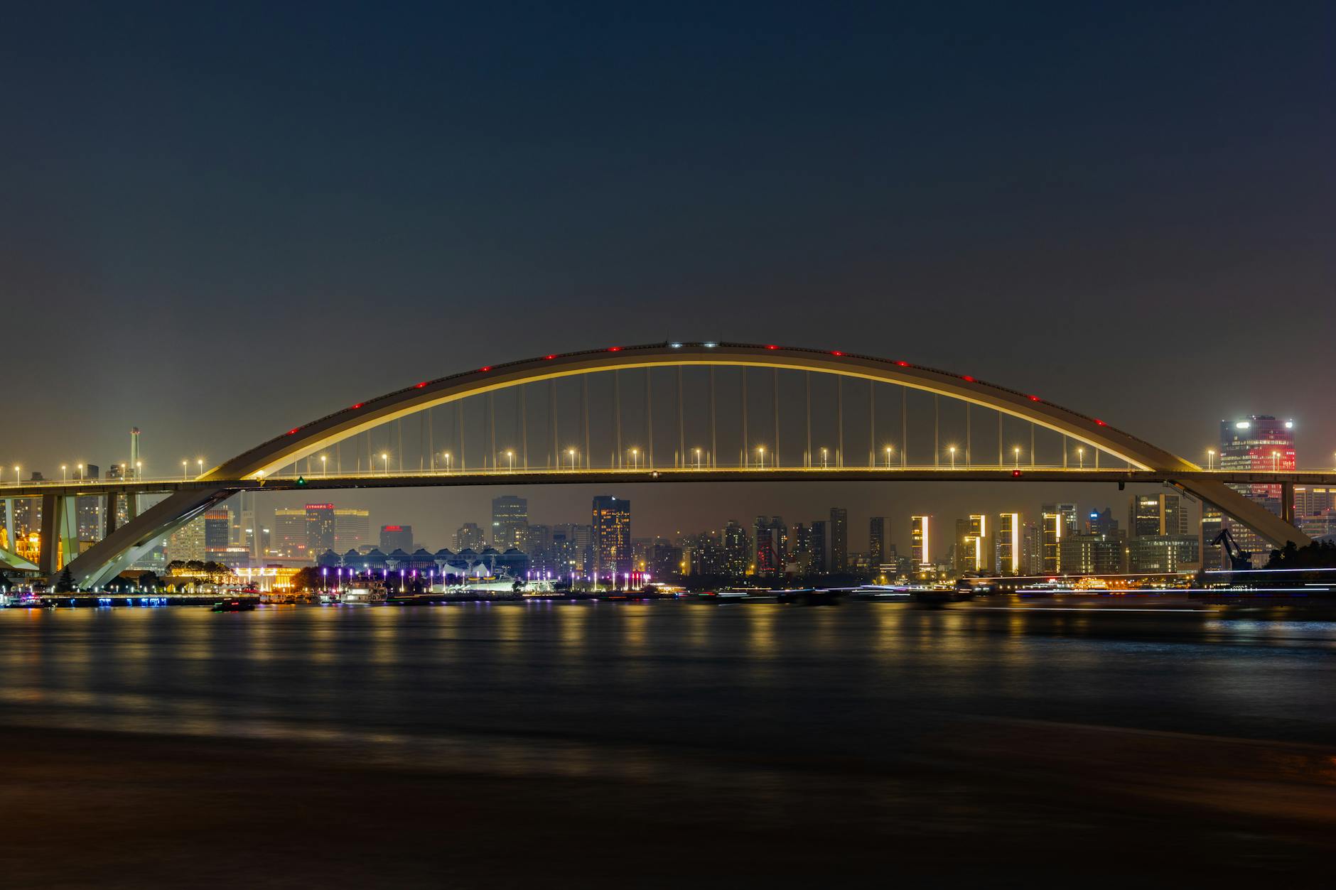 Modern bridge spanning over water connecting urban areas with traffic flowing