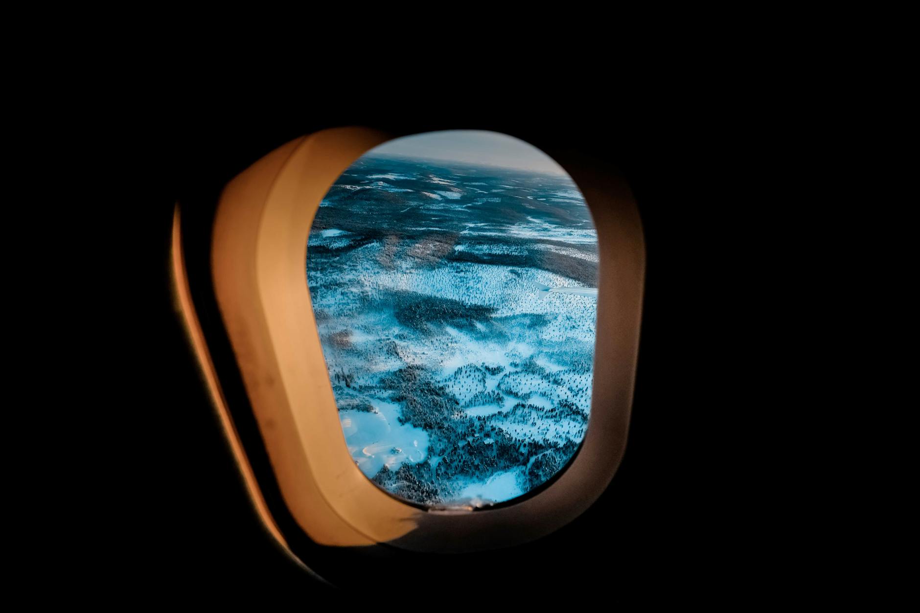View of clouds and blue sky through airplane window during flight