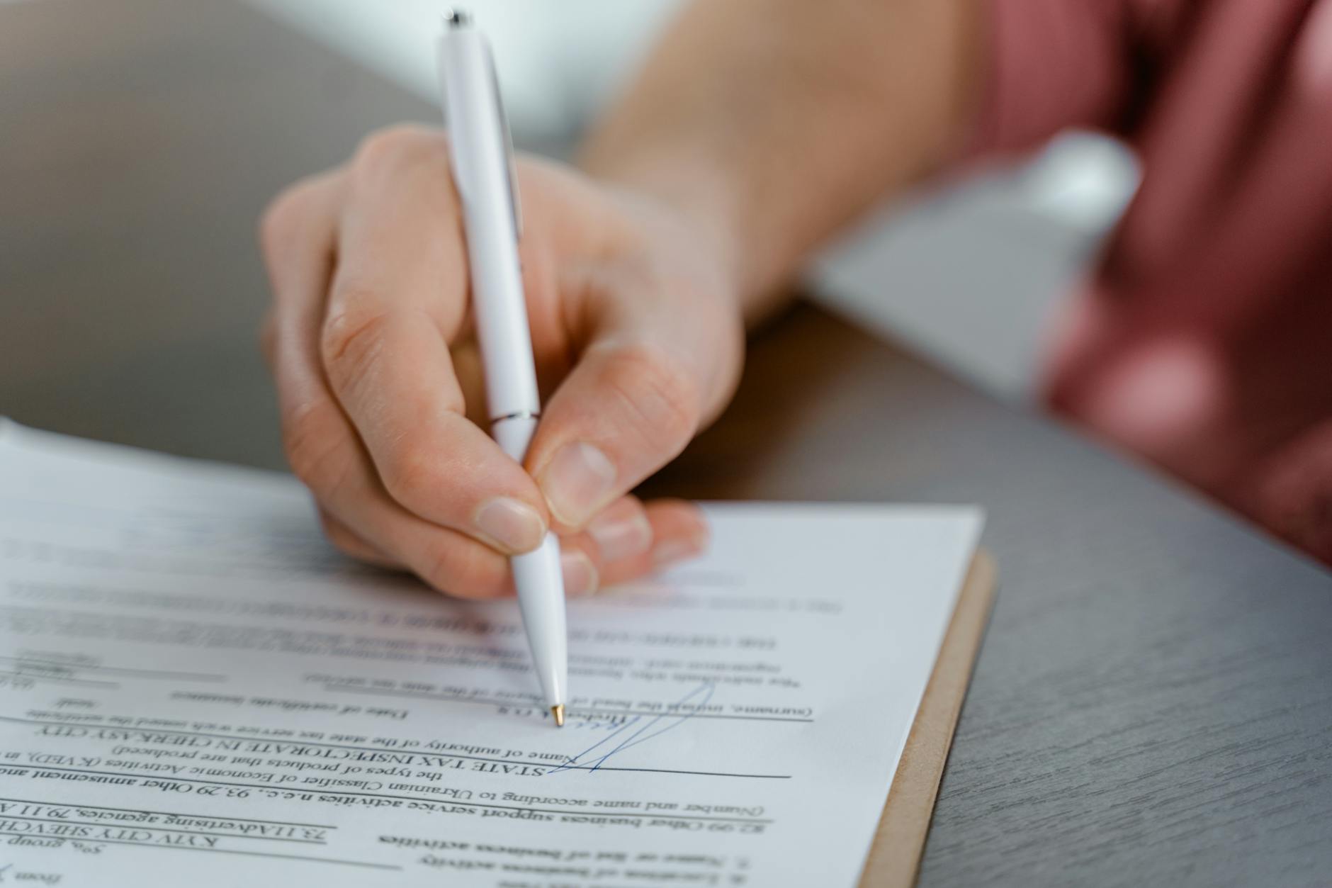 Important legal documents and contracts laid out on wooden desk with pen for signing