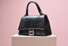 Row of pre-owned designer handbags displayed on shelves in a luxury resale boutique