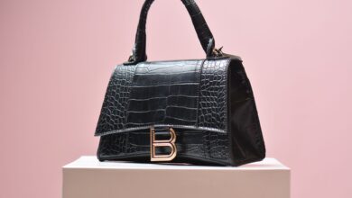 Row of pre-owned designer handbags displayed on shelves in a luxury resale boutique