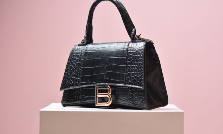 Row of pre-owned designer handbags displayed on shelves in a luxury resale boutique