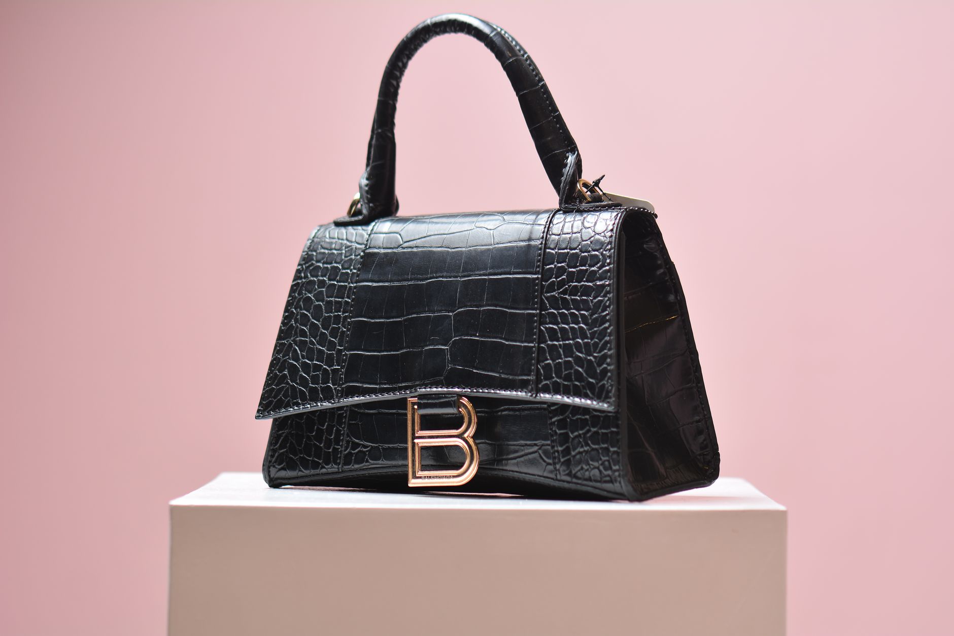 Row of pre-owned designer handbags displayed on shelves in a luxury resale boutique