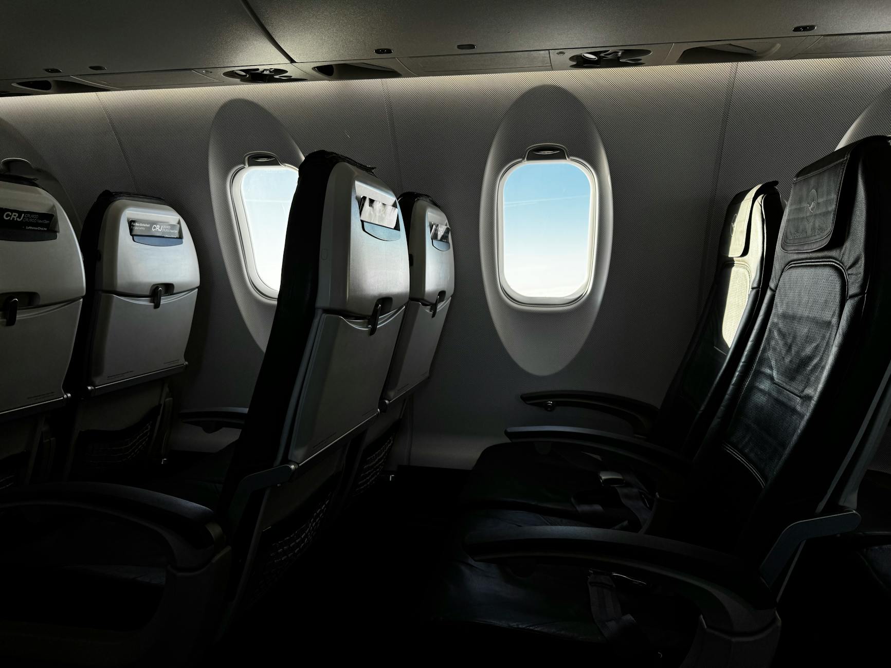 Premium economy airplane cabin interior showing comfortable seating with extra legroom