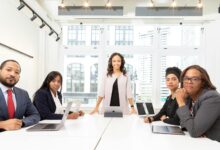 Professional business meeting with executives discussing documents around conference table