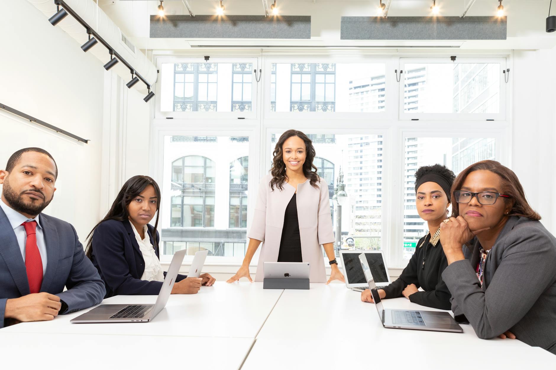 Professional business meeting with executives discussing documents around conference table