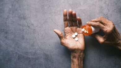Senior person holding prescription medication bottle while reading pharmacy information