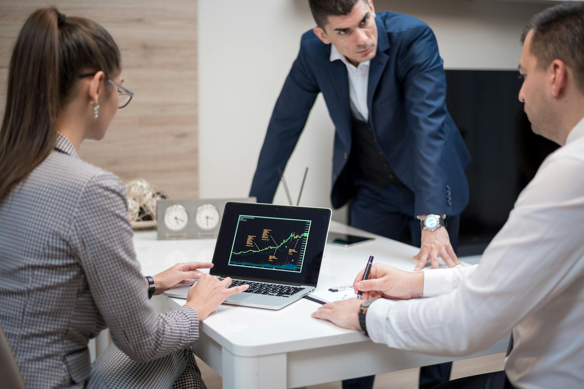 Professionals reviewing documents and financial data at a private office meeting table