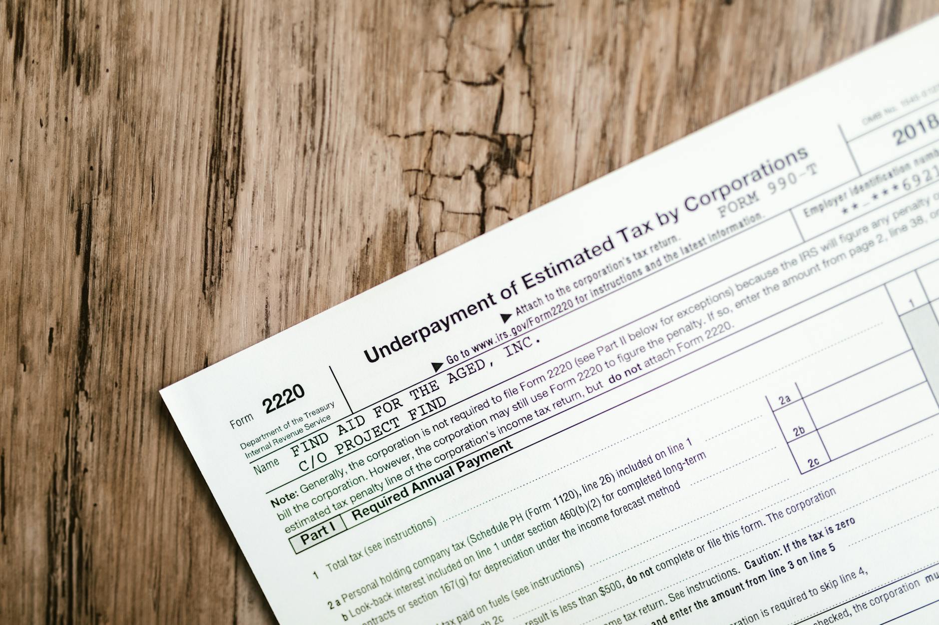 Tax compliance documents and forms spread across a desk with a pen