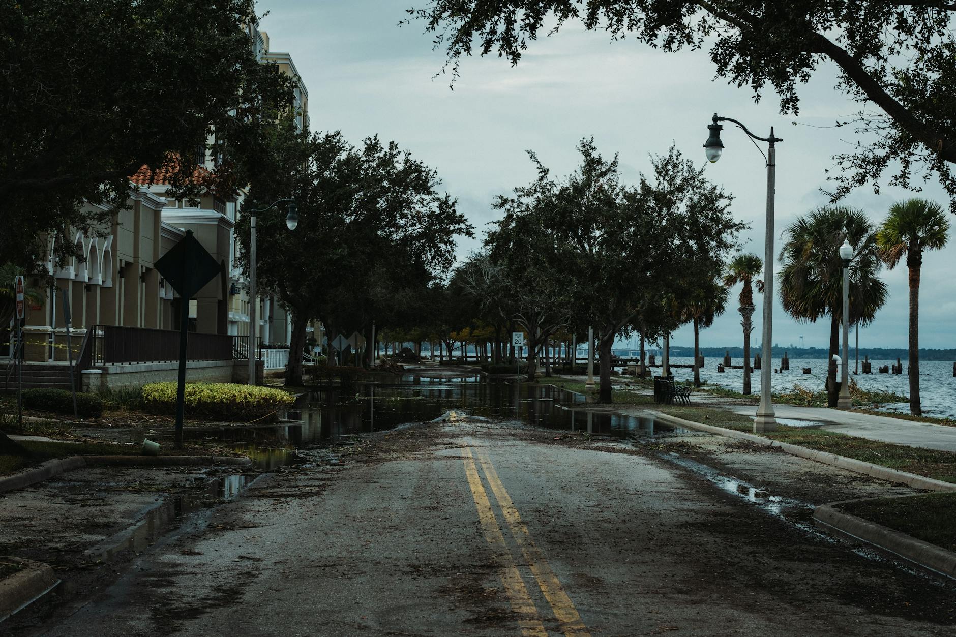 Residential street with flood water covering the pavement and affecting nearby homes