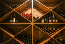 Rows of fine wine bottles stored in a dark stone cellar