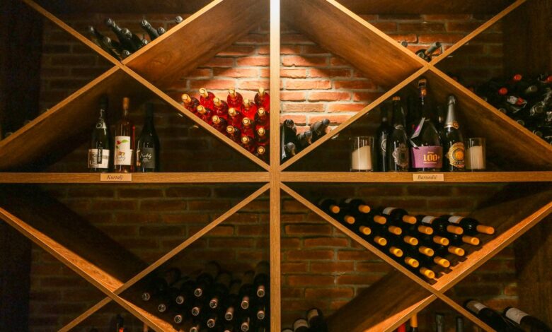 Rows of fine wine bottles stored in a dark stone cellar