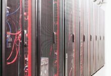 Rows of servers inside a large data center facility with blue lighting