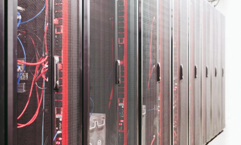 Rows of servers inside a large data center facility with blue lighting